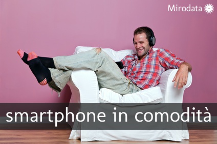 Man listening and watching a music video Con lo smartphone in poltrona